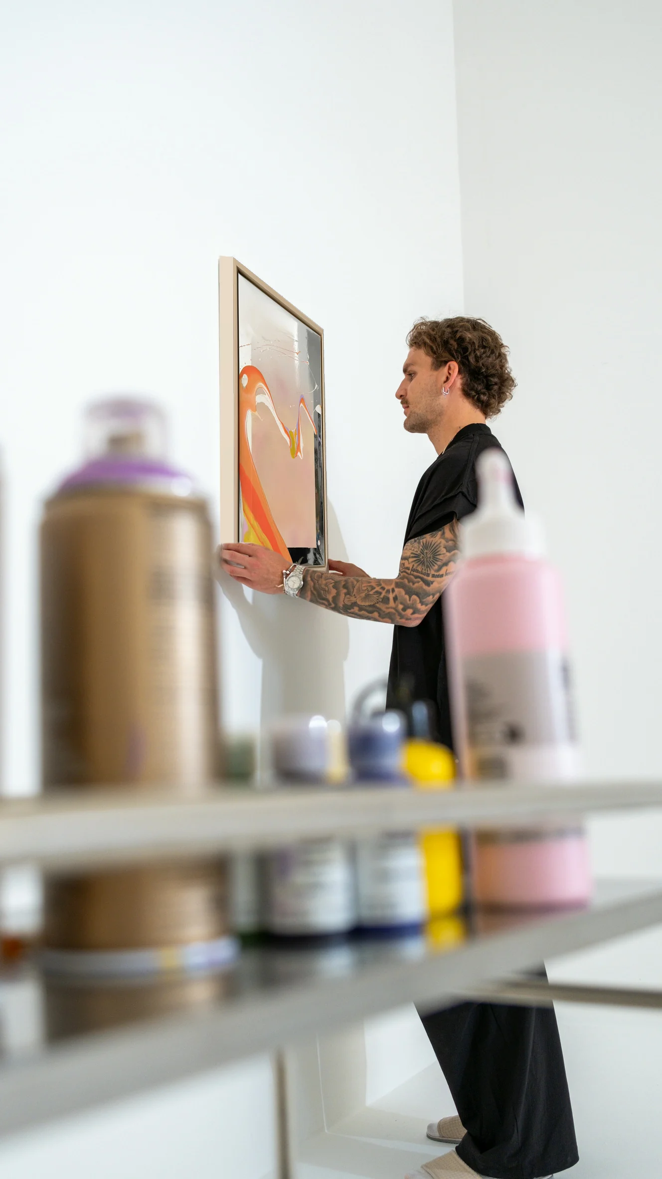 Valentin Nieroba hangs a framed WAVES OF LIFE painting in the studio